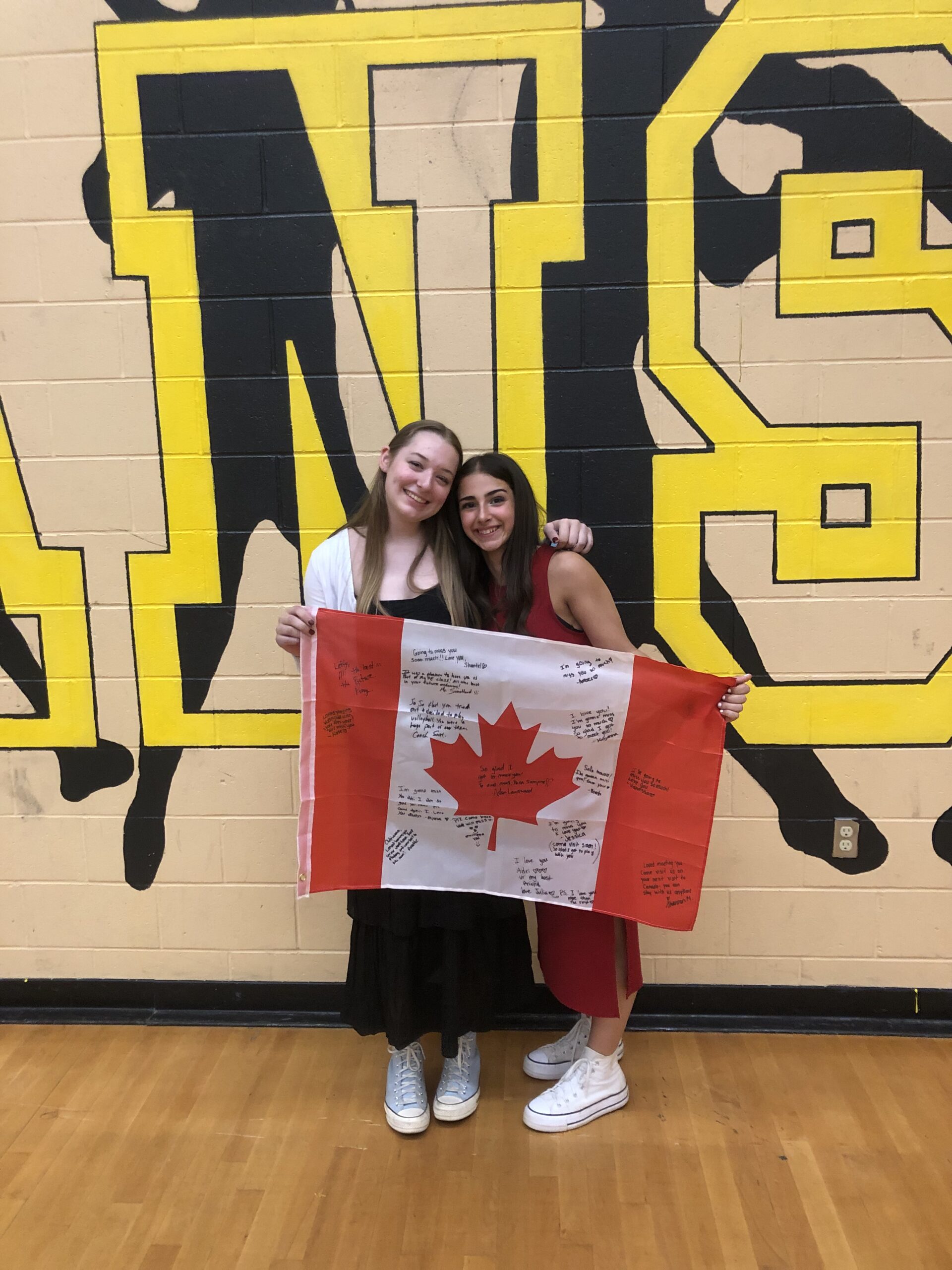 Unas estudiantes posan con la bandera de Canadá como parte de las despedidas antes del regreso a España.